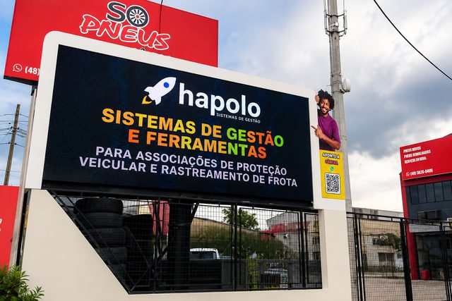 Painel de LED da BG DOOH na rua, exibindo o anúncio de um cliente, com a fachada de uma loja ao fundo.